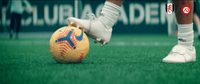 football boot on yellow football | Video Production Agency Singapore